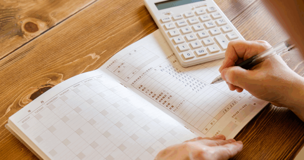 hands with a budget book and calculator