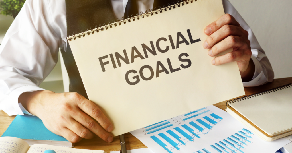 man holding a financial goals sign